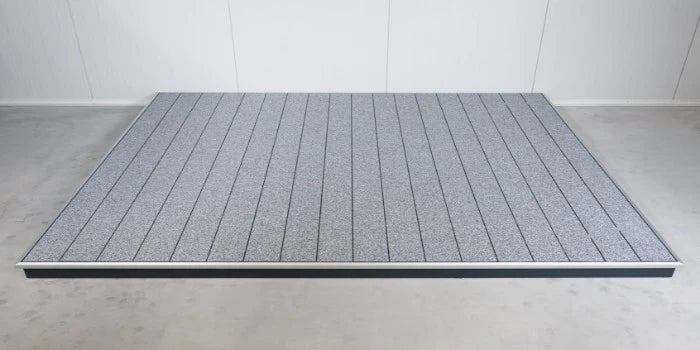 Komplett fertig verlegtes Terrassenmodul aus hochwertigen Aluminium-Terrassendielen mit grau-weißer balkoFLOOR Granitoberfläche und umlaufendem Kantenabschlussprofil